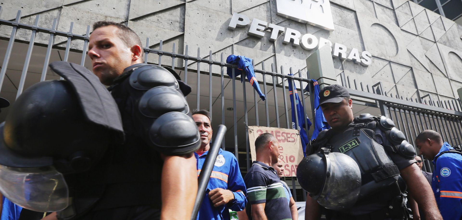 Military police watch as workers from a company sub-contracted by Brazil's government-run oil company Petroleo Brasileiro gather at a protest at the company's headquarters on Feb. 4.