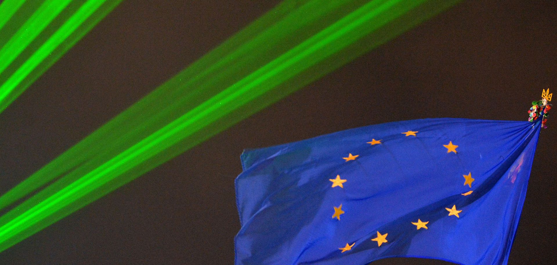A European Union flag flies above Kiev’s Maidan Square illuminated by green lights (VIKTOR DRACHEV/AFP/Getty Images)