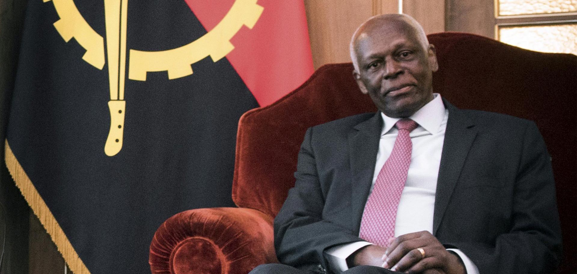 Angolan President Jose Eduardo dos Santos sits before his country's flag during a meeting with Belgian leaders in April. Dos Santos has held the presidency since 1979.