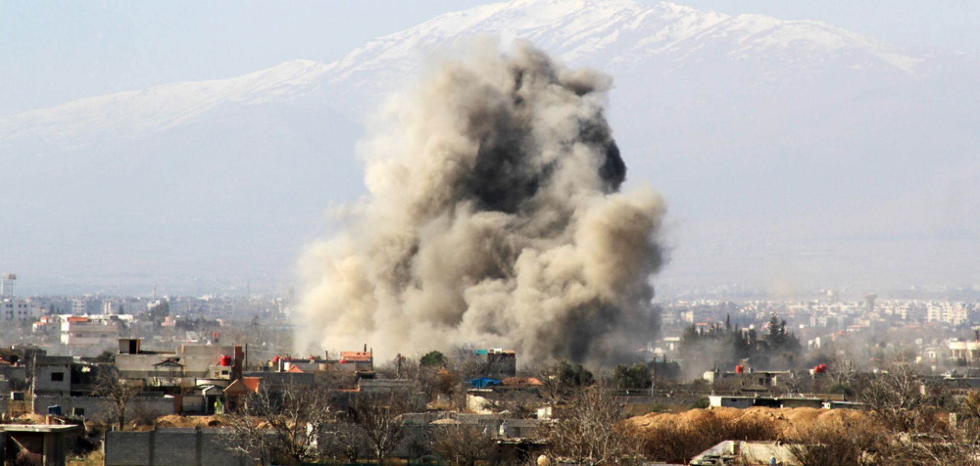 Smoke ascends after a Syrian military helicopter allegedly dropped a barrel bomb over the city of Daraya on Jan. 31.