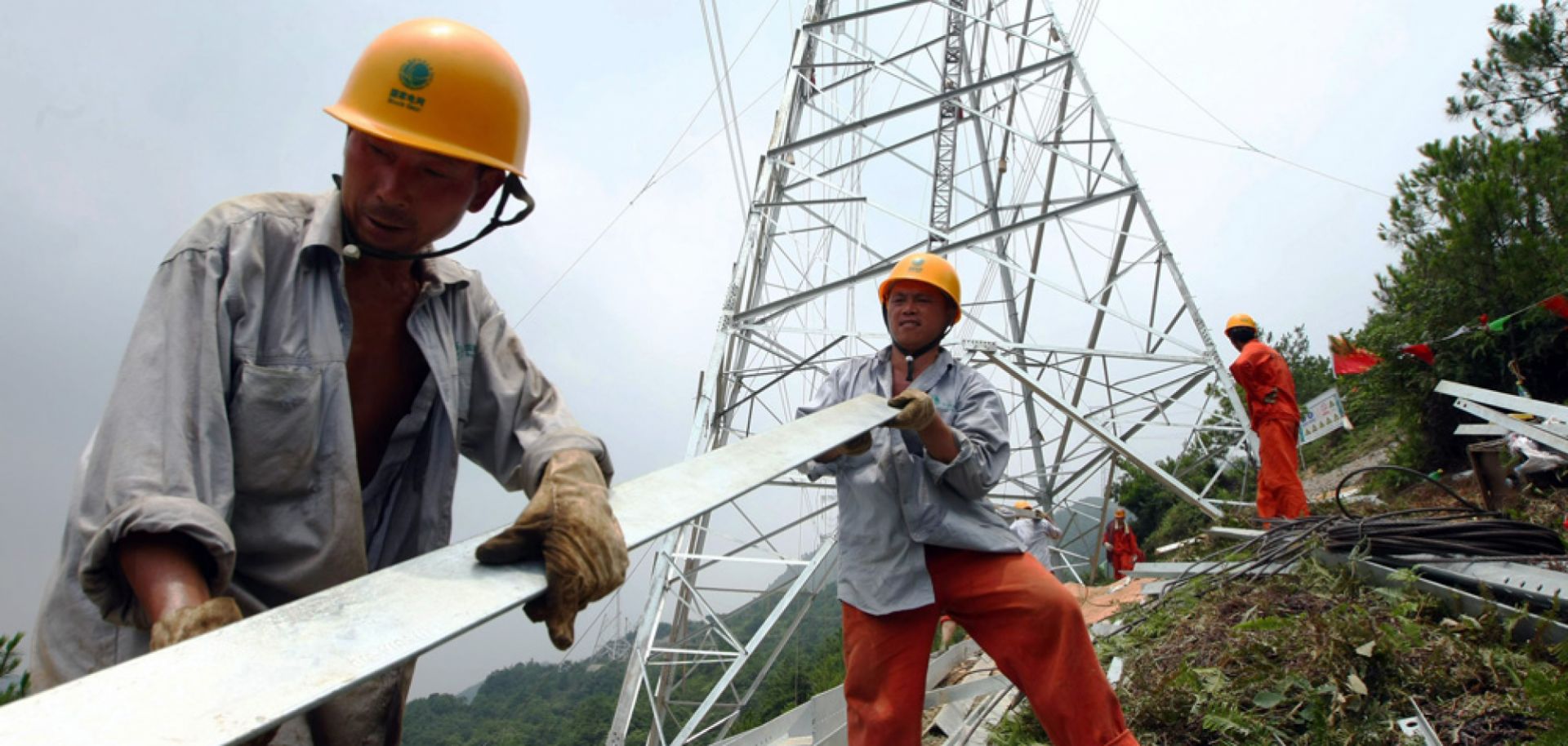 Workers build an electricity transmission tower on July 11, 2008 in Yongjia County of Zhejiang Province