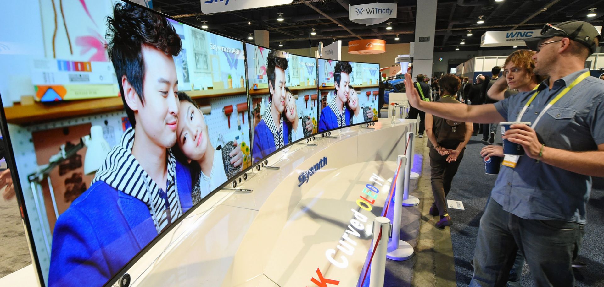 Attendees look at 65-inch Skyworth 4K curved OLED televisions on display at the 2015 International CES at the Las Vegas Convention Center.