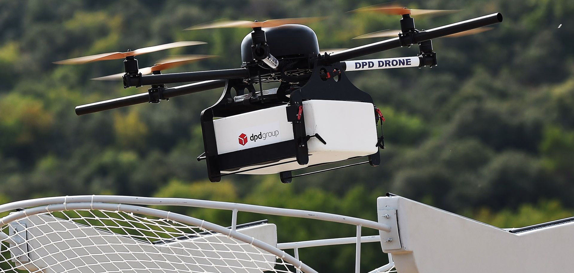 A French Geopost drone hovers, showing a prototype package delivery system in action in France. In the United States, regulations will delay the use of drones in urban environments and home deliveries.