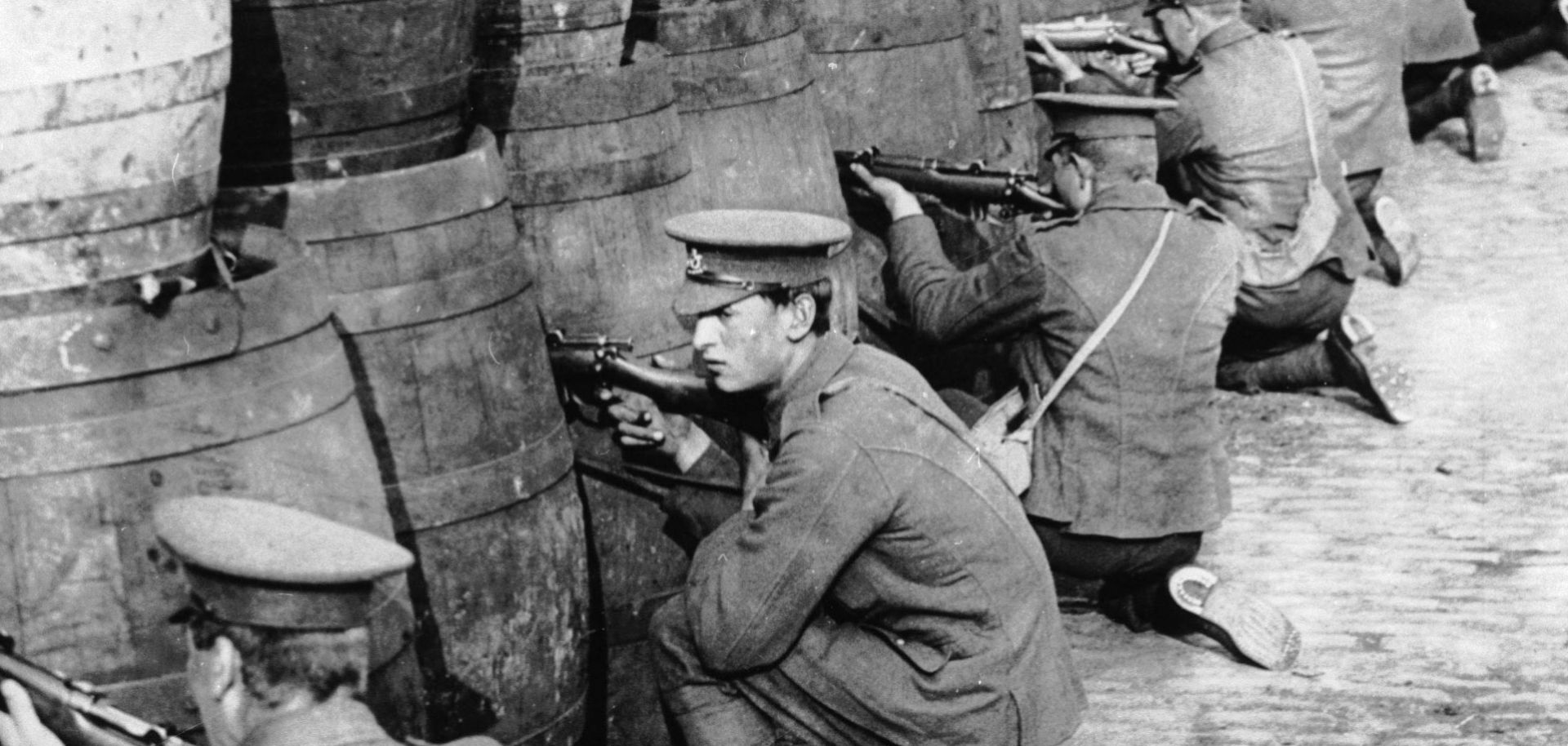 British soldiers sniping from behind a barricade of empty beer casks near the quays in Dublin during the 1916 Easter Rising. 