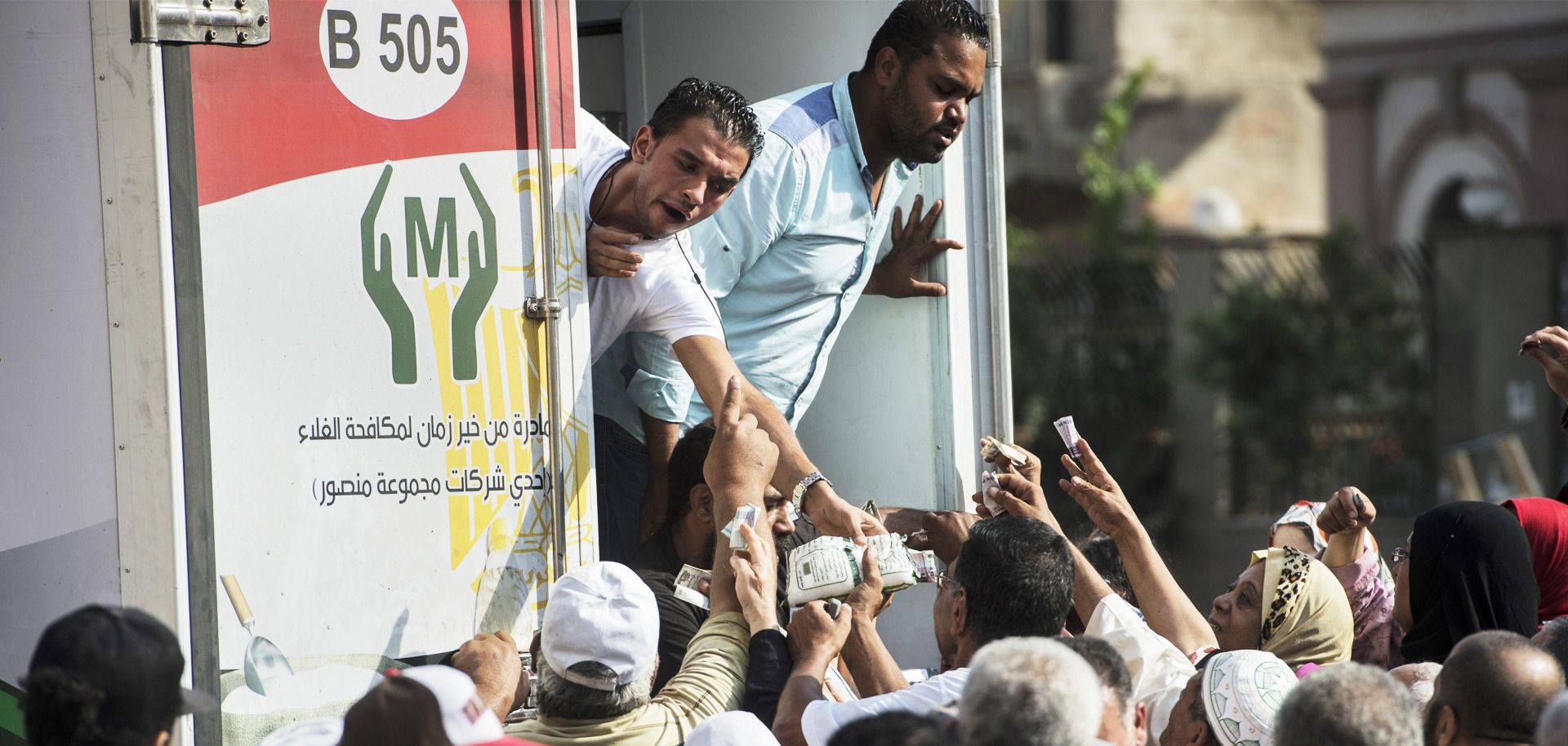 Egyptians buy sugar from a truck in Cairo. The government is struggling to keep stores stocked with subsidized goods.