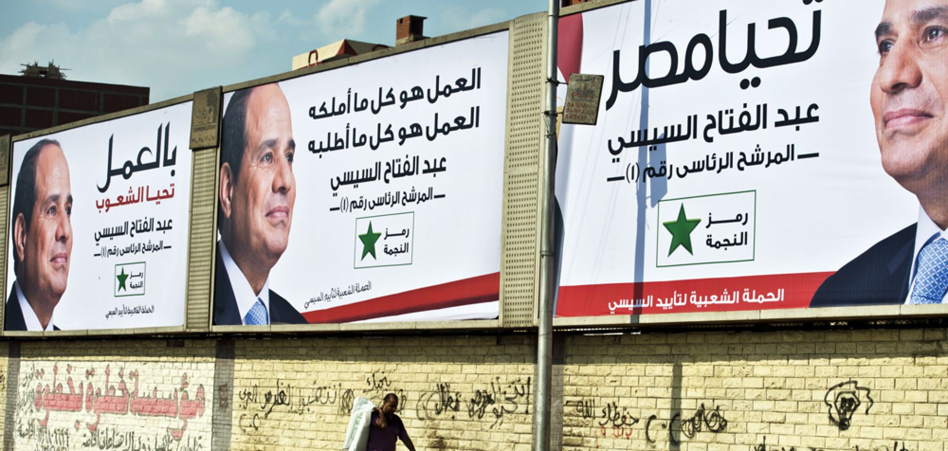 An Egyptian man walks under posters of Egypt's former army chief and leading presidential candidate Abdel Fattah al-Sisi in Cairo on May 12.