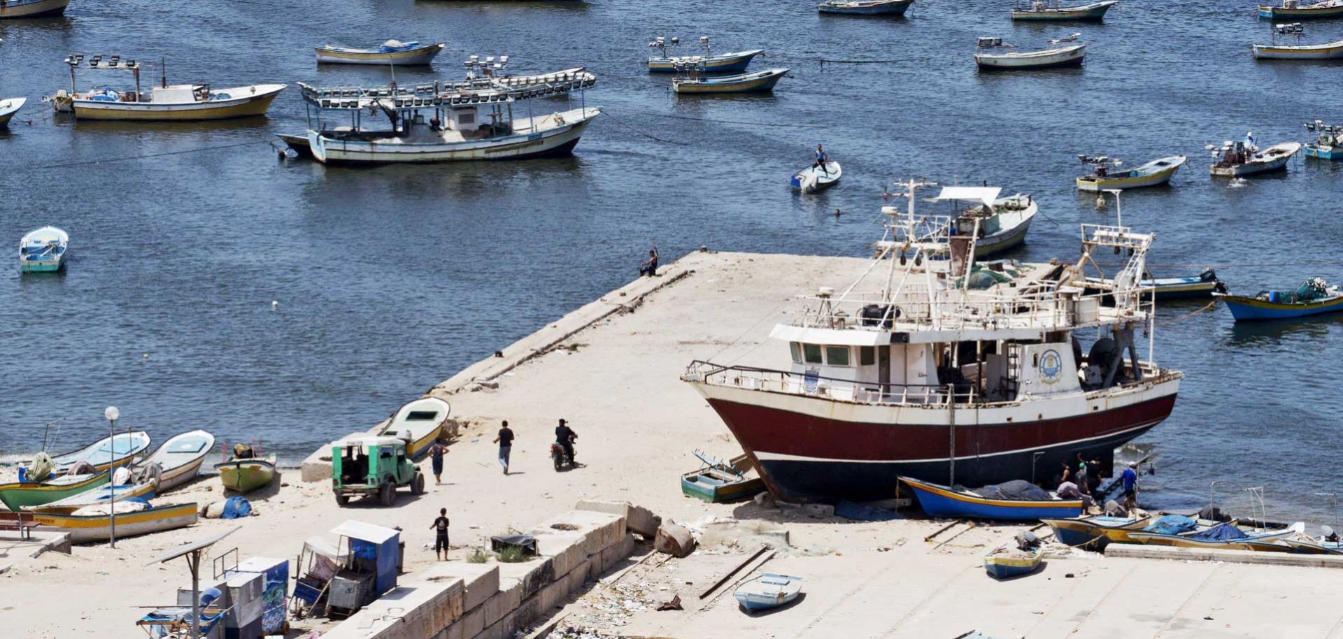 Fishing vessels are moored at Gaza City's harbour on August 18, 2014. Egyptian-brokered indirect negotiations between Israel and the Palestinians are taking place in Egypt during a five-day lull in the fighting that is due to expire at midnight (2100 GMT). The Palestinians have rejected any call to disarm Gaza and are pushing for Israel to lift its eight-year blockade on the coastal territory and also want the establishment of a sea port and an airport. AFP PHOTO/ROBERTO SCHMIDT (Photo credit should read RO