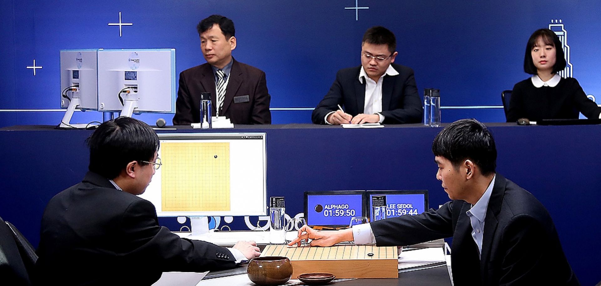 South Korean professional Go player Lee Sedol (R) puts his first stone in a match against Google artificial intelligence program AlphaGo, which eventually won four of five games.