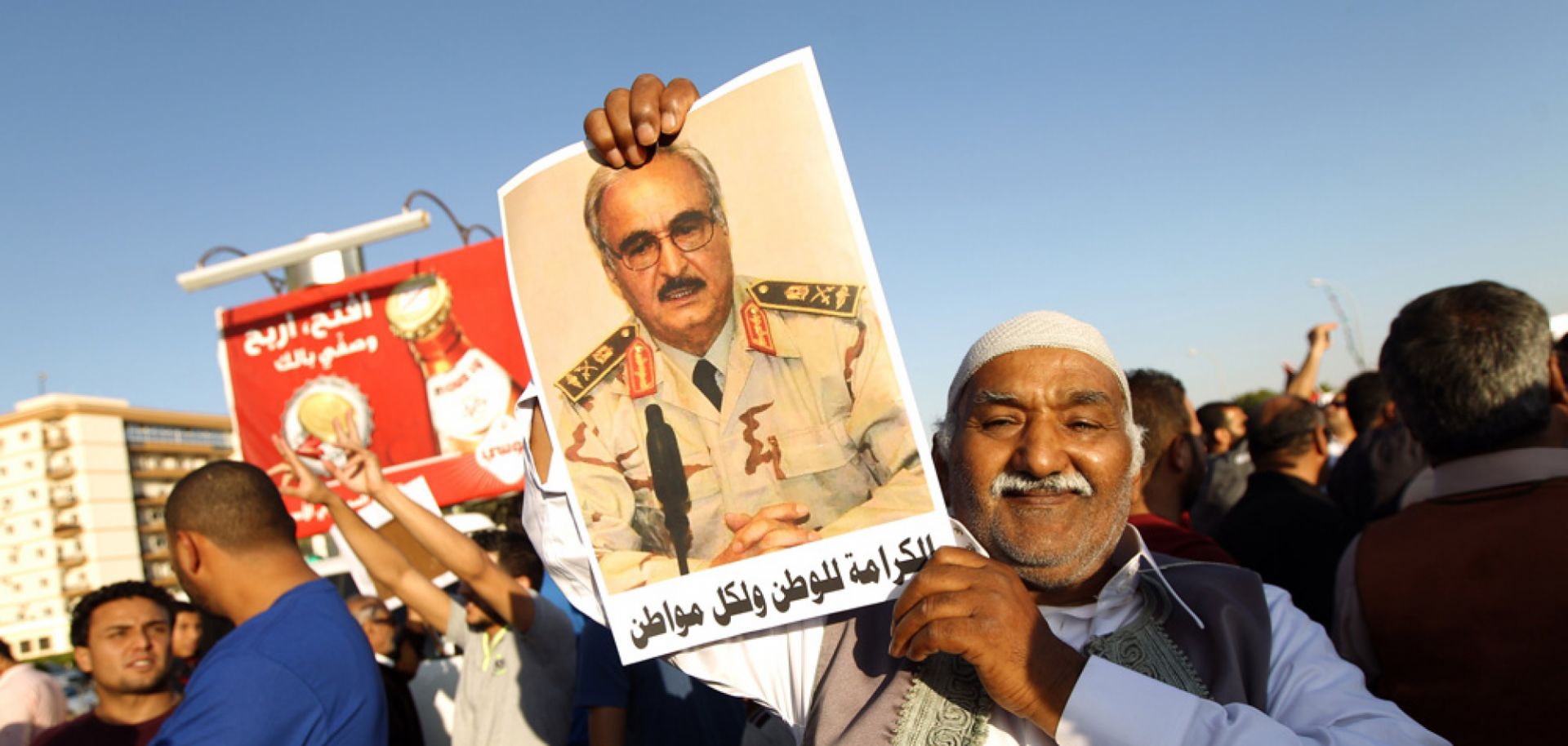 A Libyan man carries a portrait of retired Gen. Khalifa Hifter.