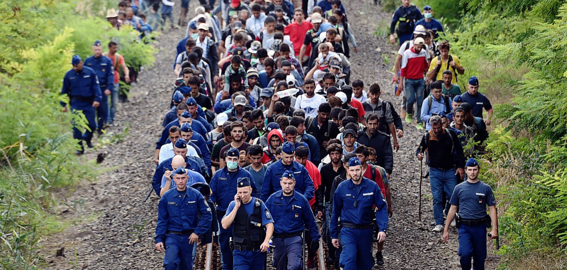 Refugees from various countries walk along railway tracks near the Hungarian town of Szeged.