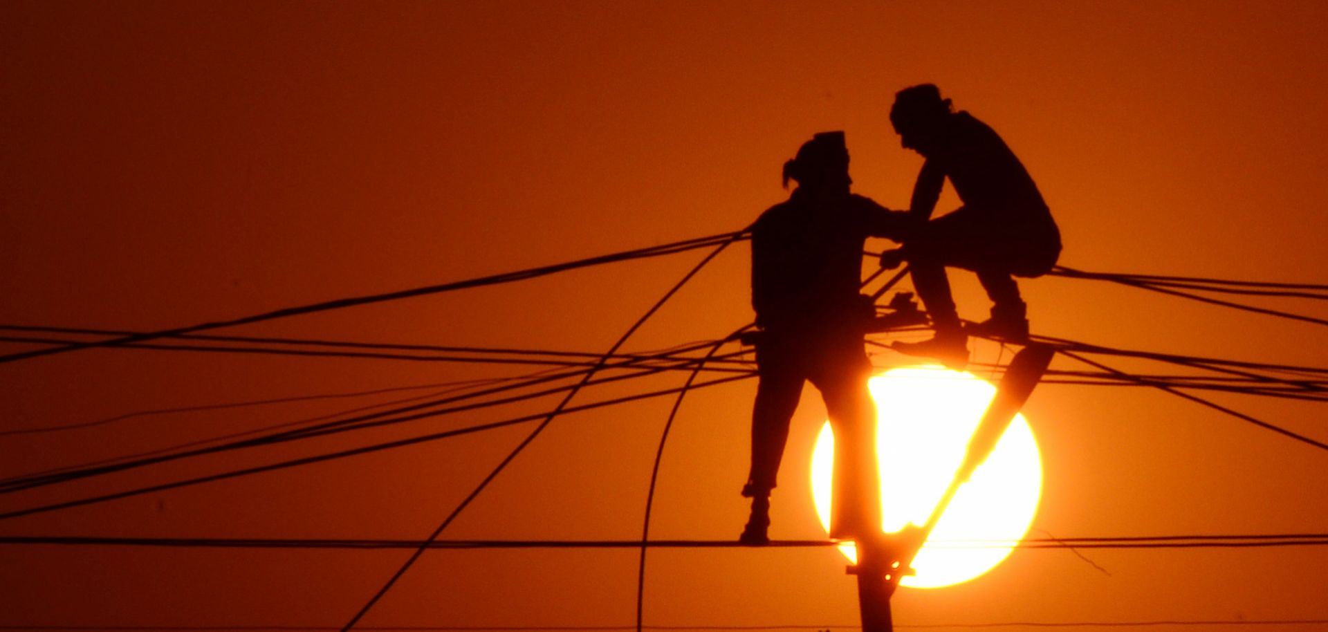 Indian workers adjust electricity cables ahead of the Kumbh Mela festival on Dec. 26, 2015. 