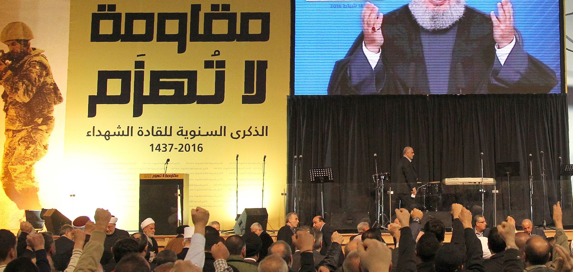 The Head of Lebanon's Shiite movement Hezbollah, Hassan Nasrallah, is seen on a giant screen as he addresses the crowd in a televised speech from an undisclosed location during a rally held in the southern suburbs of Beirut on February 16, 2016, to mark the anniversary of the Israeli killings of Lebanese Hezbollah commanders Ragheb Harb, Abbas al-Mussawi and Imad Mughnieh. Mussawi was killed on February 16, 1992 in an Israeli air raid on Nabatiyeh, Harb was assassinated in south Lebanon during Israel's occu