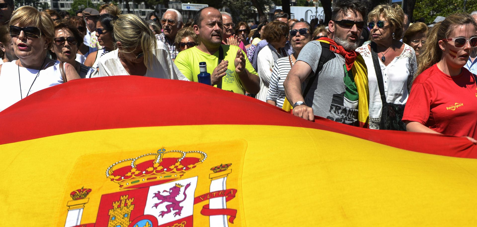 Supporters of Spain's ruling Popular Party march behind a Spanish flag in Madrid on May 30, 2015 during a demonstration following the party’s loss of votes in the recent regional and municipal elections.