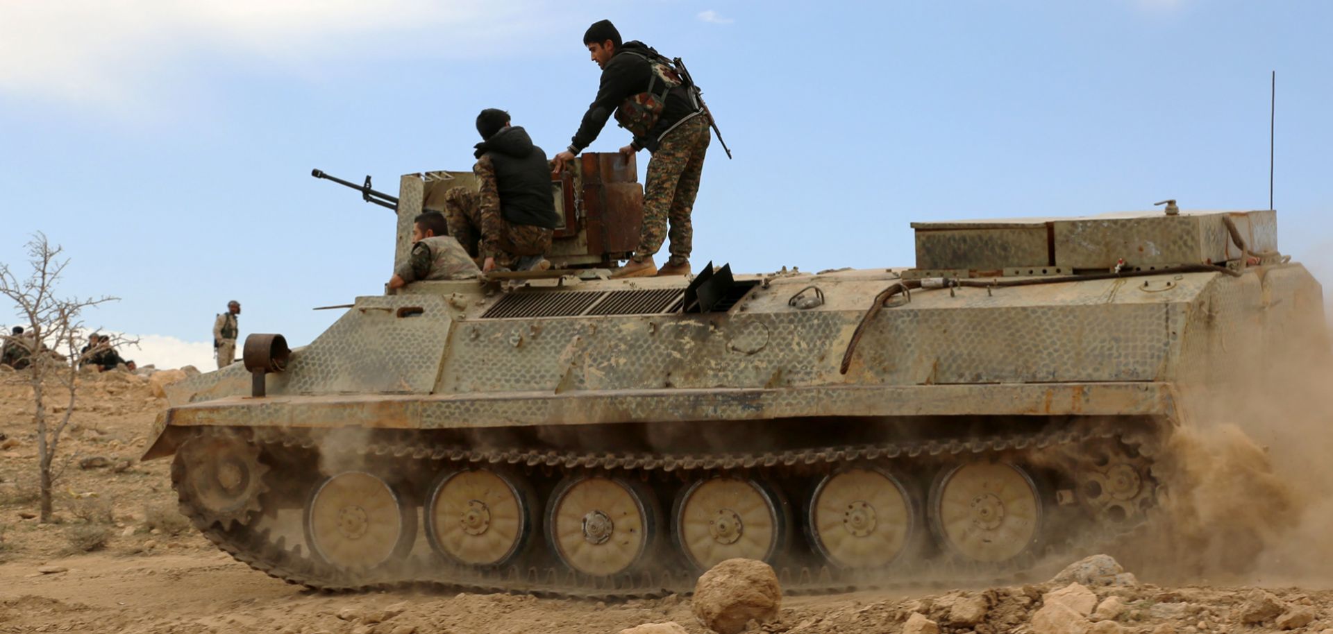 Fighters belonging to the Syrian Democratic Forces sit on an armored personnel carrier in al-Hasaka province on Feb. 19.