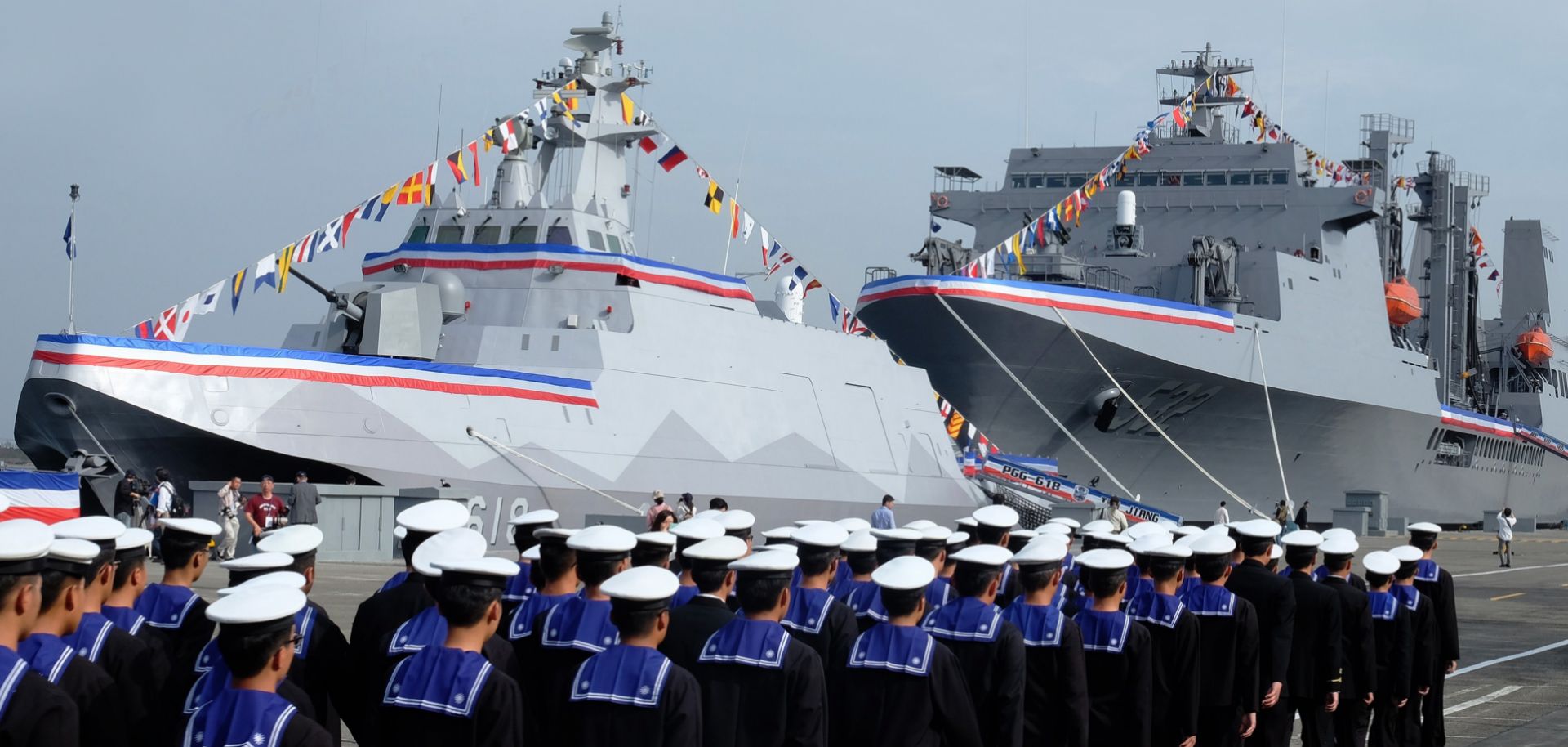 Taiwanese naval personnel walk past a Tuo Chiang-class missile boat in southern Kaohsiung on March 31.