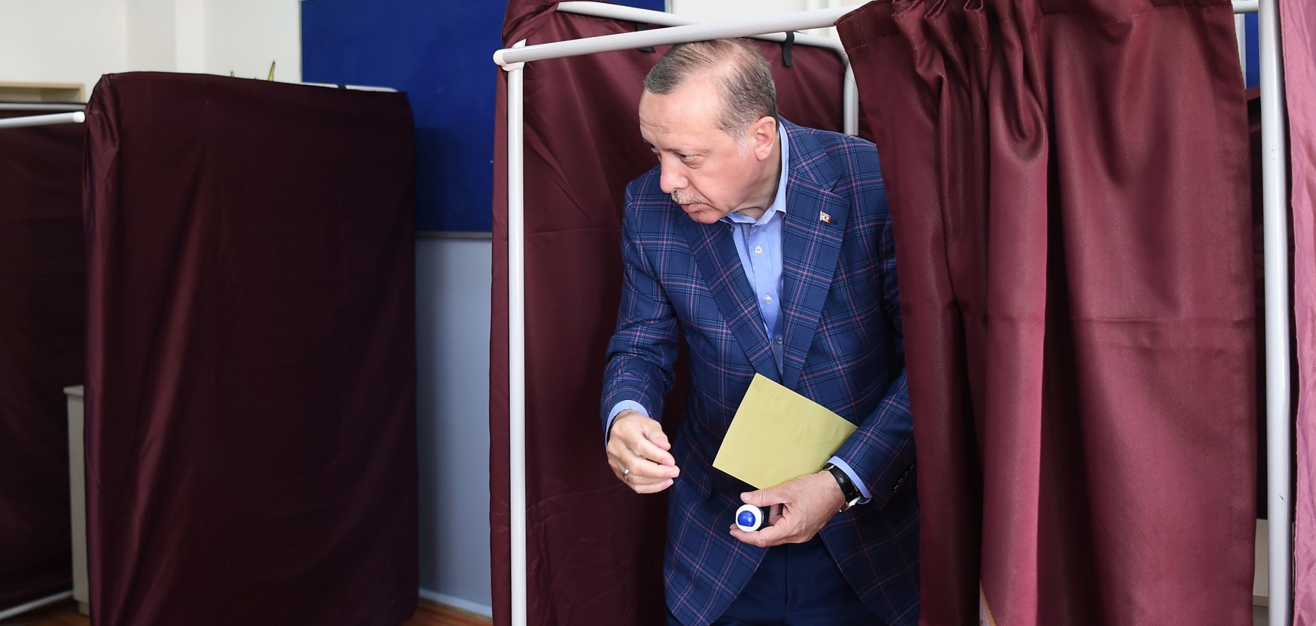 Turkish President Recep Tayyip Erdogan emerges from a voting booth.