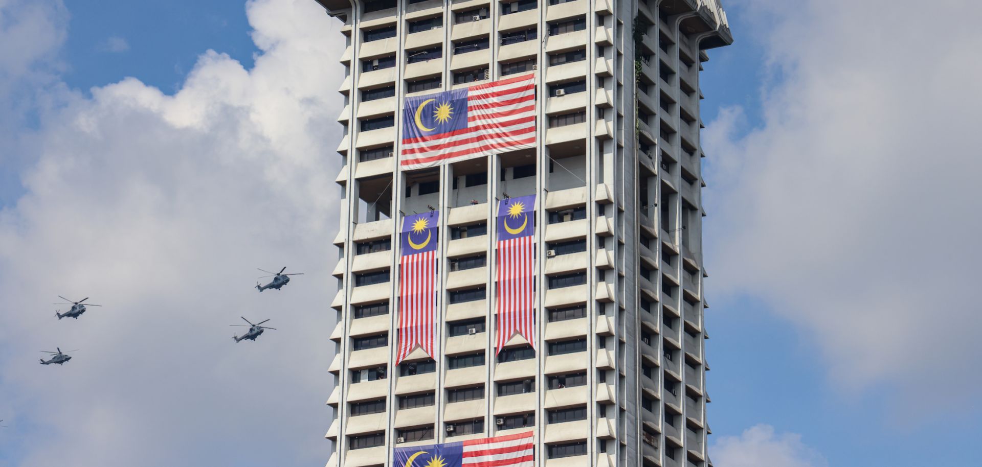 Royal Malaysian Air Force helicopters fly past a building during the 65th National Day parade at Independence Square on Aug. 31, 2022, in Kuala Lumpur, Malaysia. 