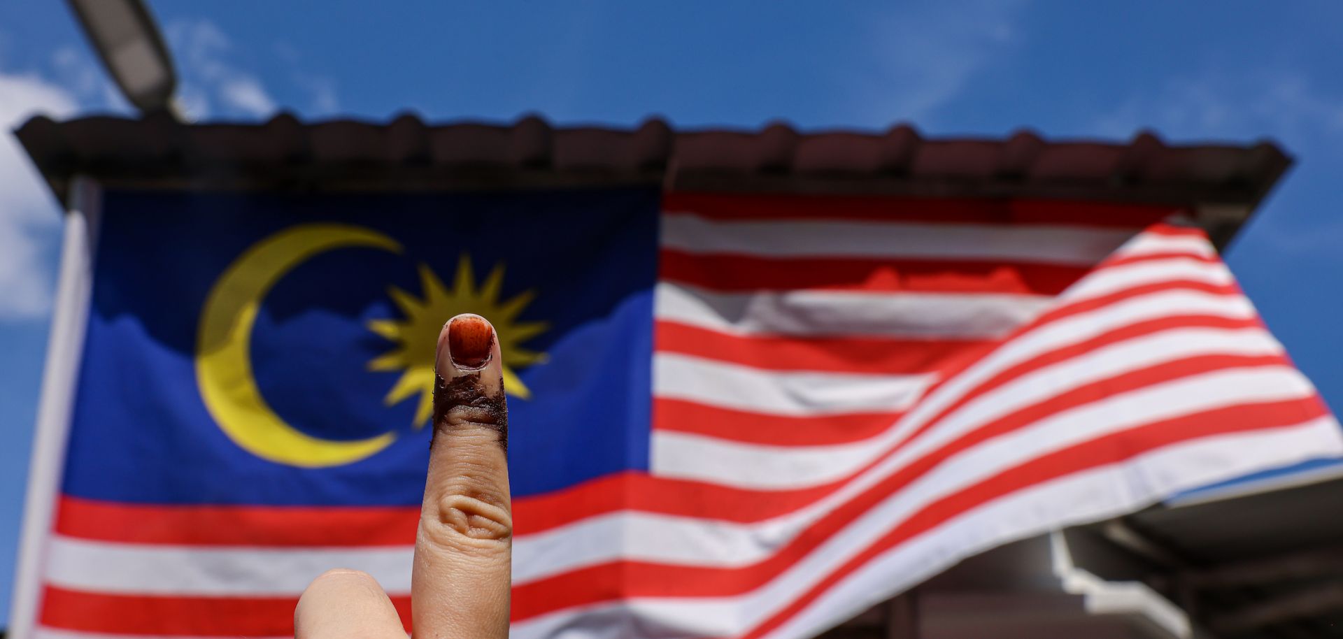 A voter shows a fading inked finger from casting a vote during Malaysia's Nov. 19 general election on Nov. 22, 2022, in Petaling Jaya, Malaysia.