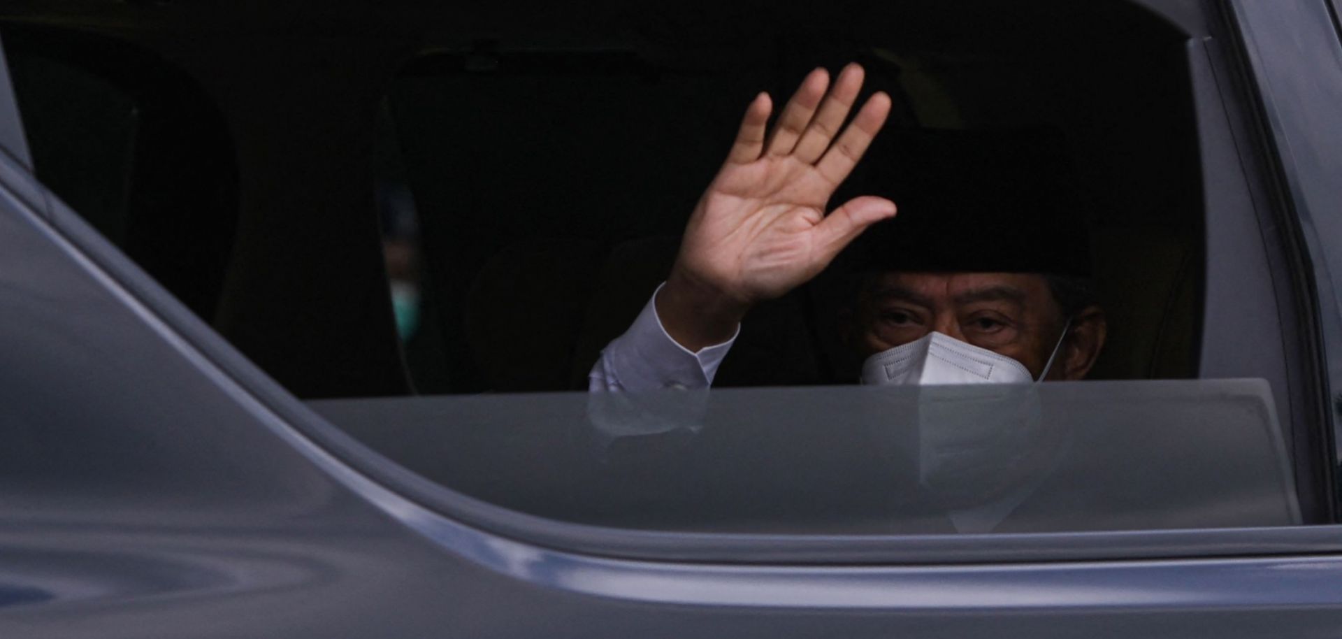 Malaysian Prime Minister Muhyiddin Yassin waves as he arrives at the national palace in Kuala Lumpur on Aug. 16, 2021. 