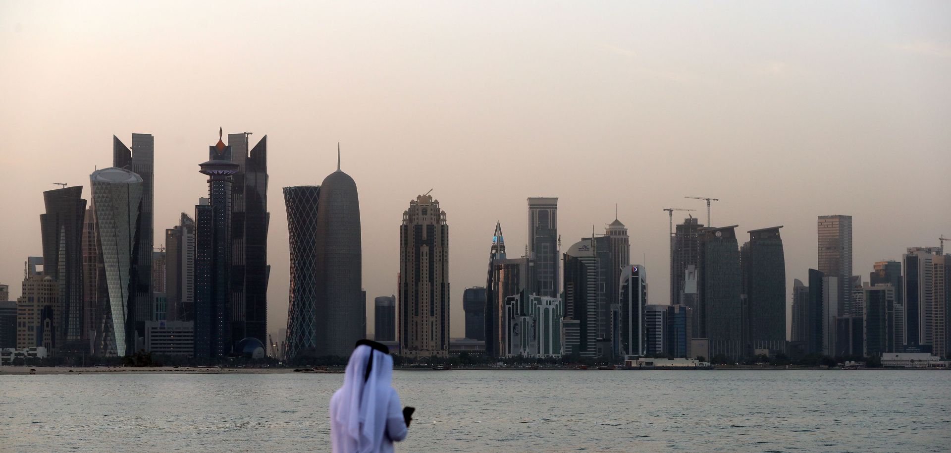 A man looks at his phone on the corniche in the Qatari capital Doha.