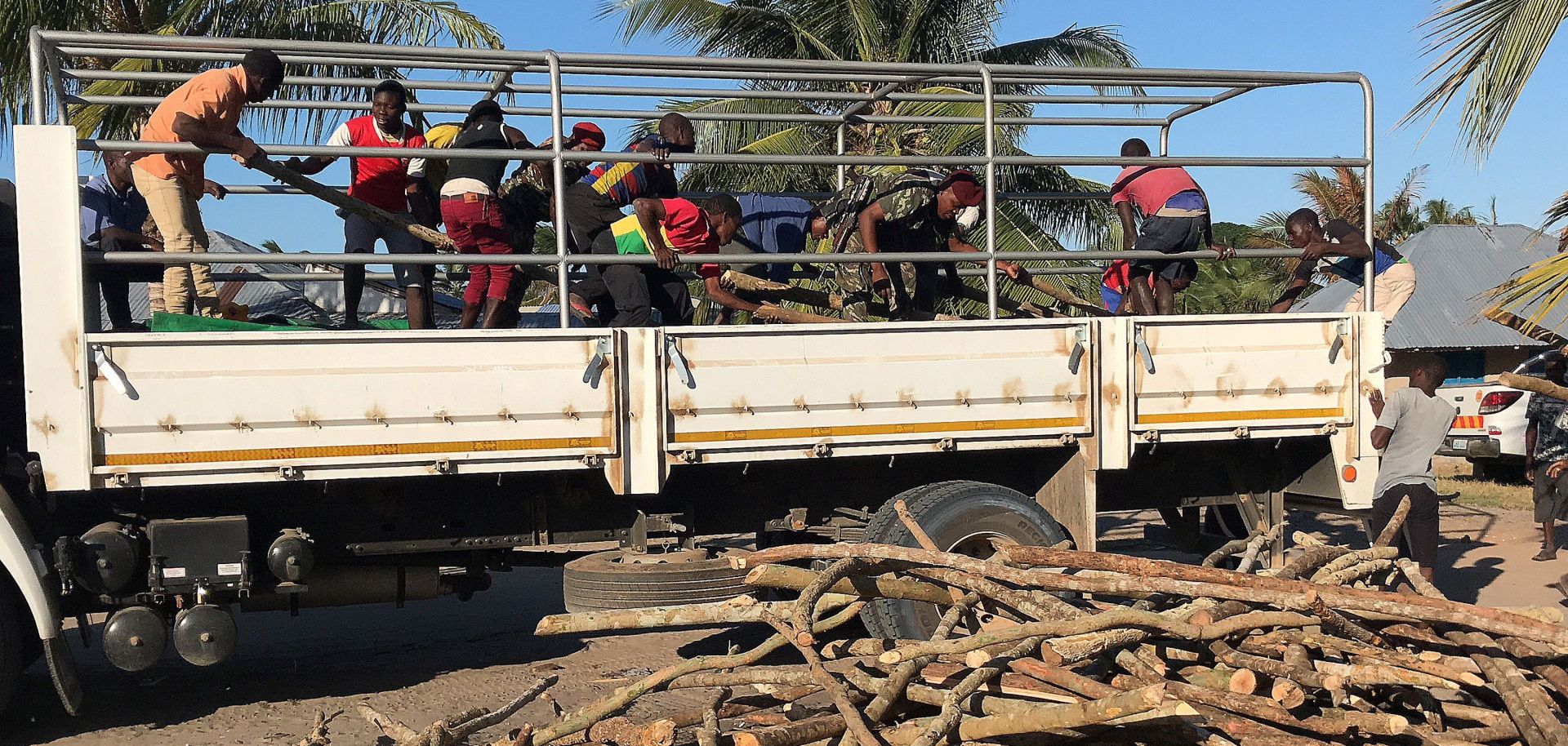 A picture shows internally displaced people and residents unload a truck with goods of first necessity, food and blankets in Naunde, northern Mozambique on June 13, after fleeing the recent attacks. 