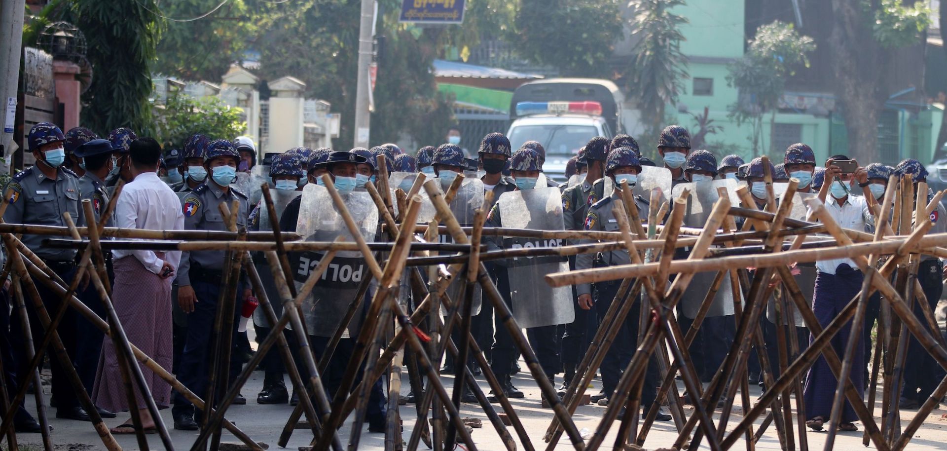 Riot police approach protesters' barricades in an attempt to disperse a March 4, 2021, demonstration in Naypyidaw, Myanmar, against the military coup.