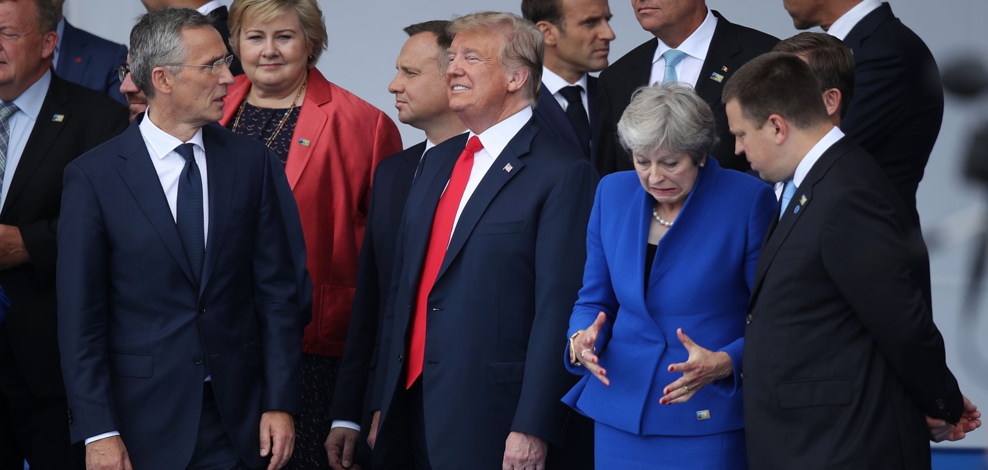 NATO Secretary-General Jens Stoltenberg (L), U.S. President Donald Trump (C) and British Prime Minister Theresa May (R) mingle with other NATO representatives at the opening ceremony for the military bloc's annual summit in Brussels on July 11, 2018.