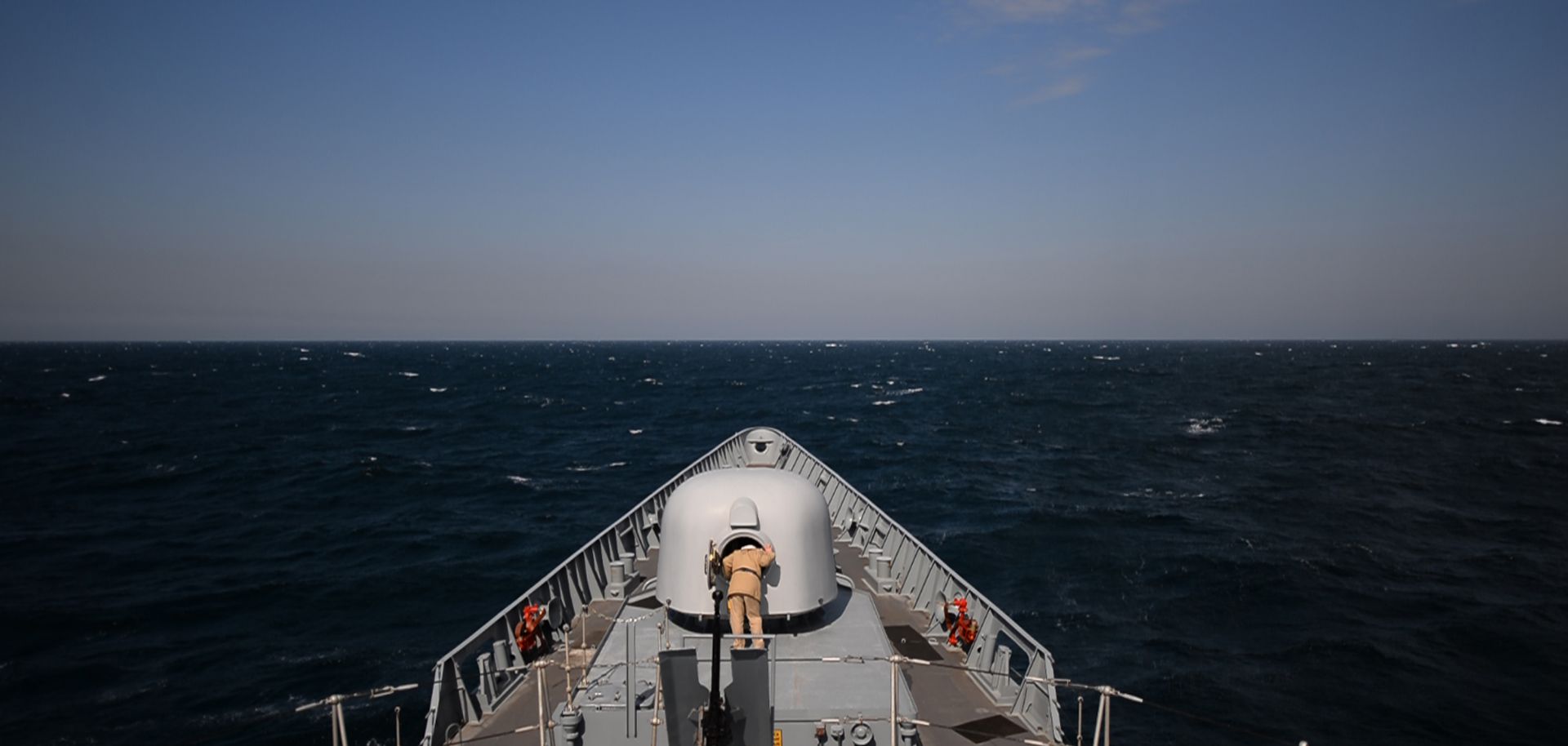 A navy man inspect a cannon on a ship in the Black Sea.