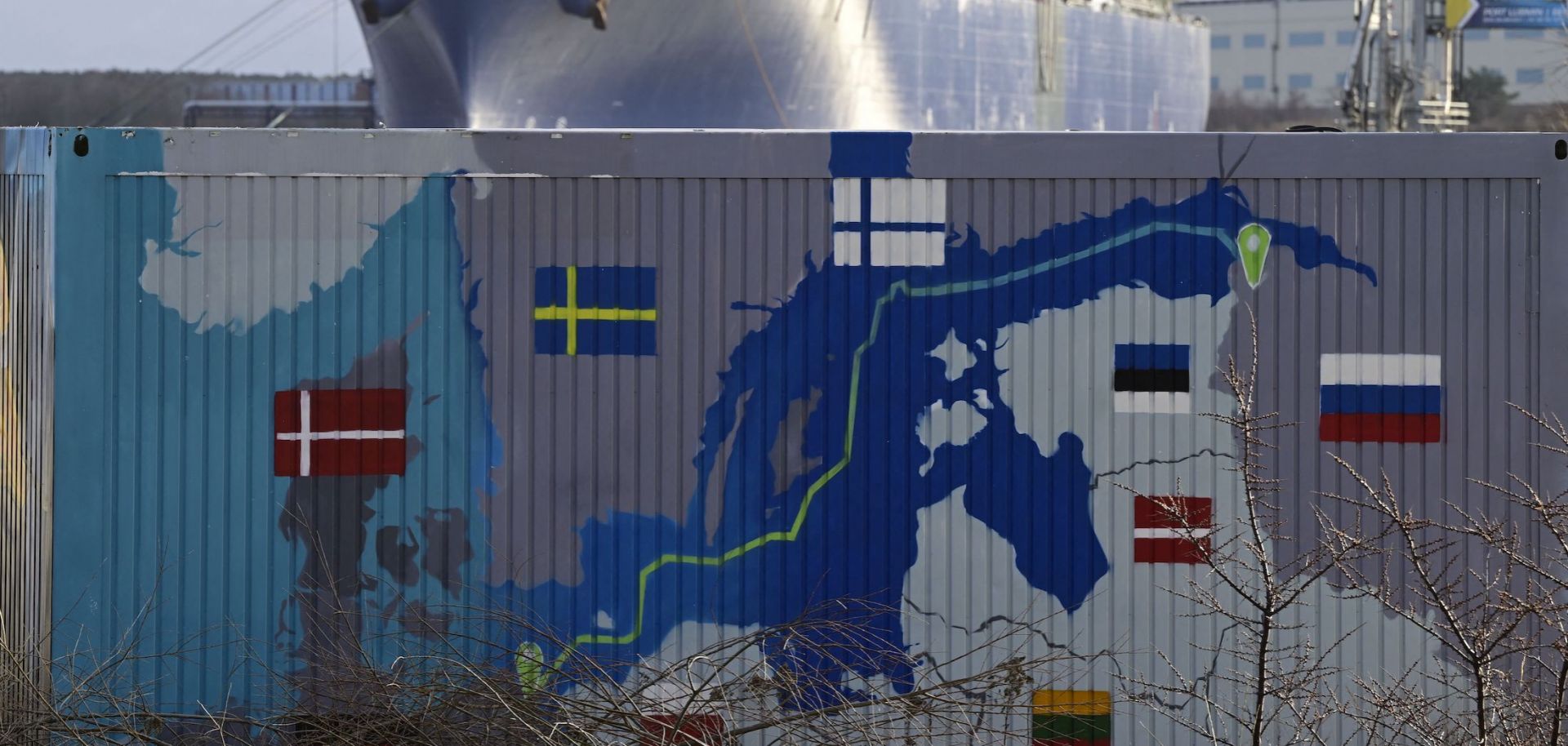 A floating storage and regasification unit (FSRU) is pictured behind a container painted with a map showing the Nord Stream 2 gas pipeline in Lubmin, northeastern Germany, on Jan. 14, 2023. 