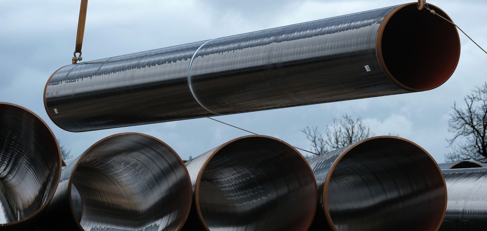 A section of pipe hangs from a crane at a construction site of the Eugal gas pipeline in Germany, which will transport natural gas arriving from Russia through the Nord Stream 2 pipeline.