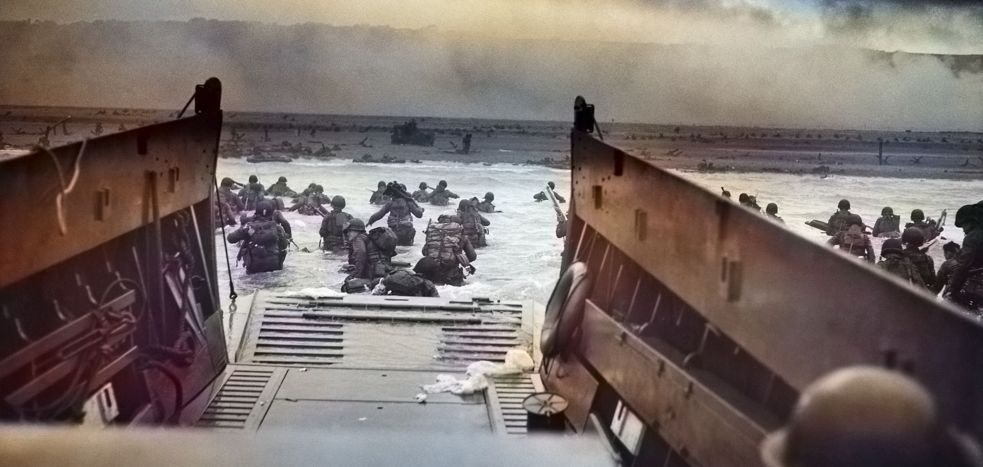 A digitally colorized image of a photograph by Robert F. Sargent titled "Into the Jaws of Death." Sargent captured troops from the United States Army First Infantry Division disembarking from an LCVP (landing craft) onto Omaha Beach during the Normandy Landings on D-Day during World War II, June 6, 1944.