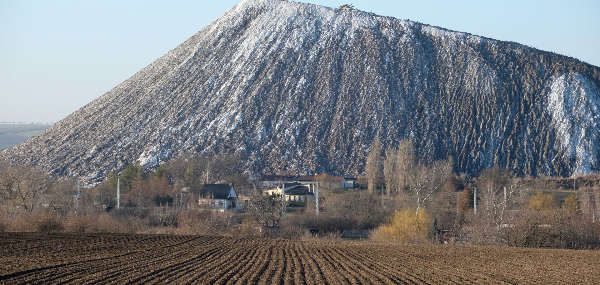 A field with an overburden heap of a former potash plant in the distance.