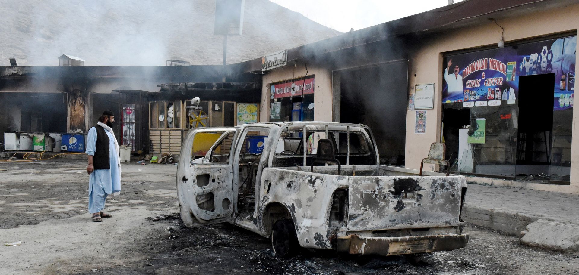 A man looks at damage from a Balochistan Liberation Army attack Jan. 30 in central Bolan district in Balochistan province, Pakistan.