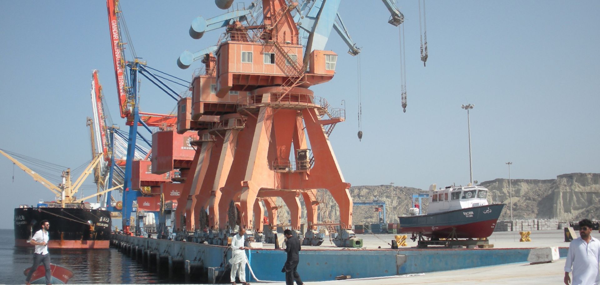 Workers in Pakistan walk around the Gwadar port, one of the many development projects in China's Belt and Road Initiative.