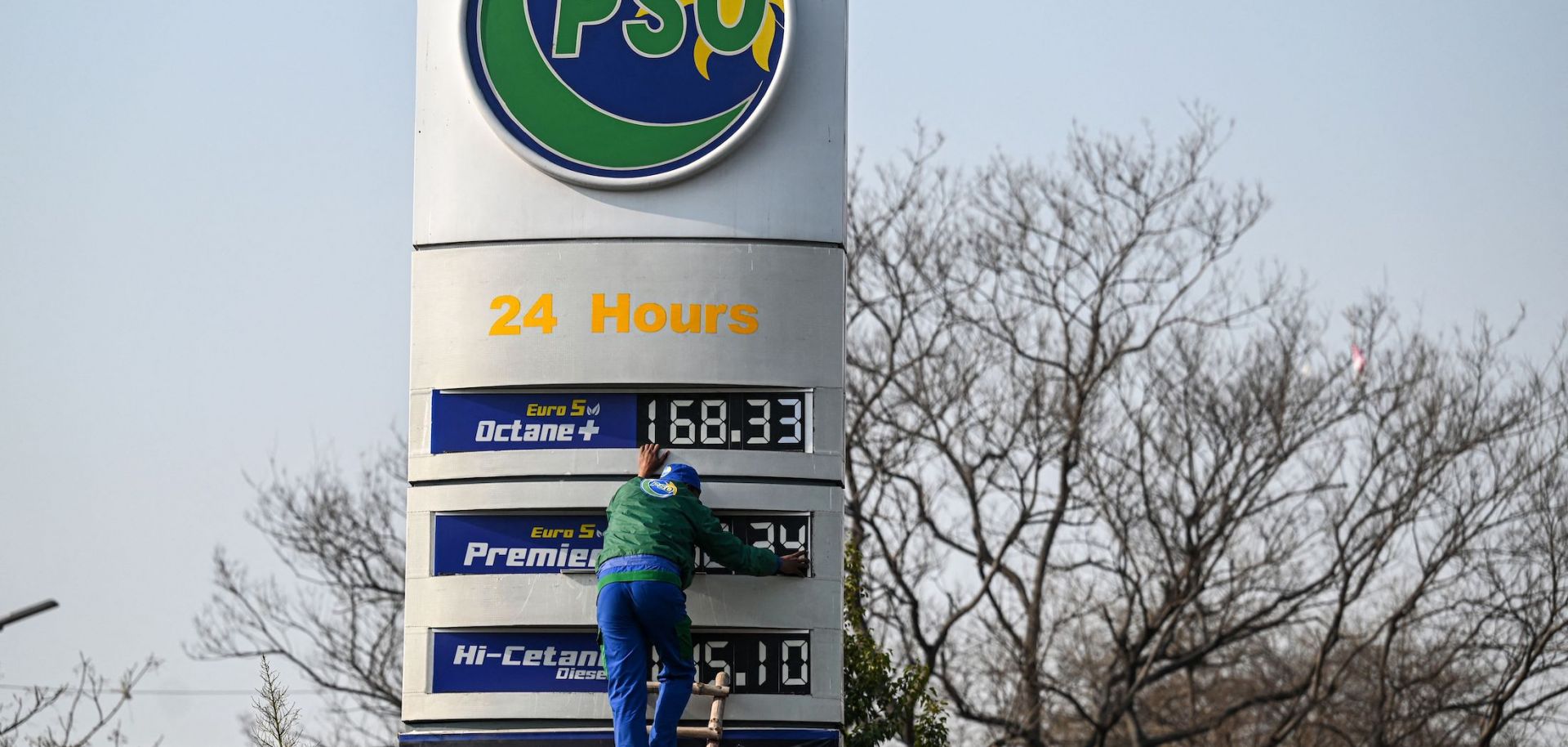 An employee of a fuel station updates the latest fuel price list in Islamabad