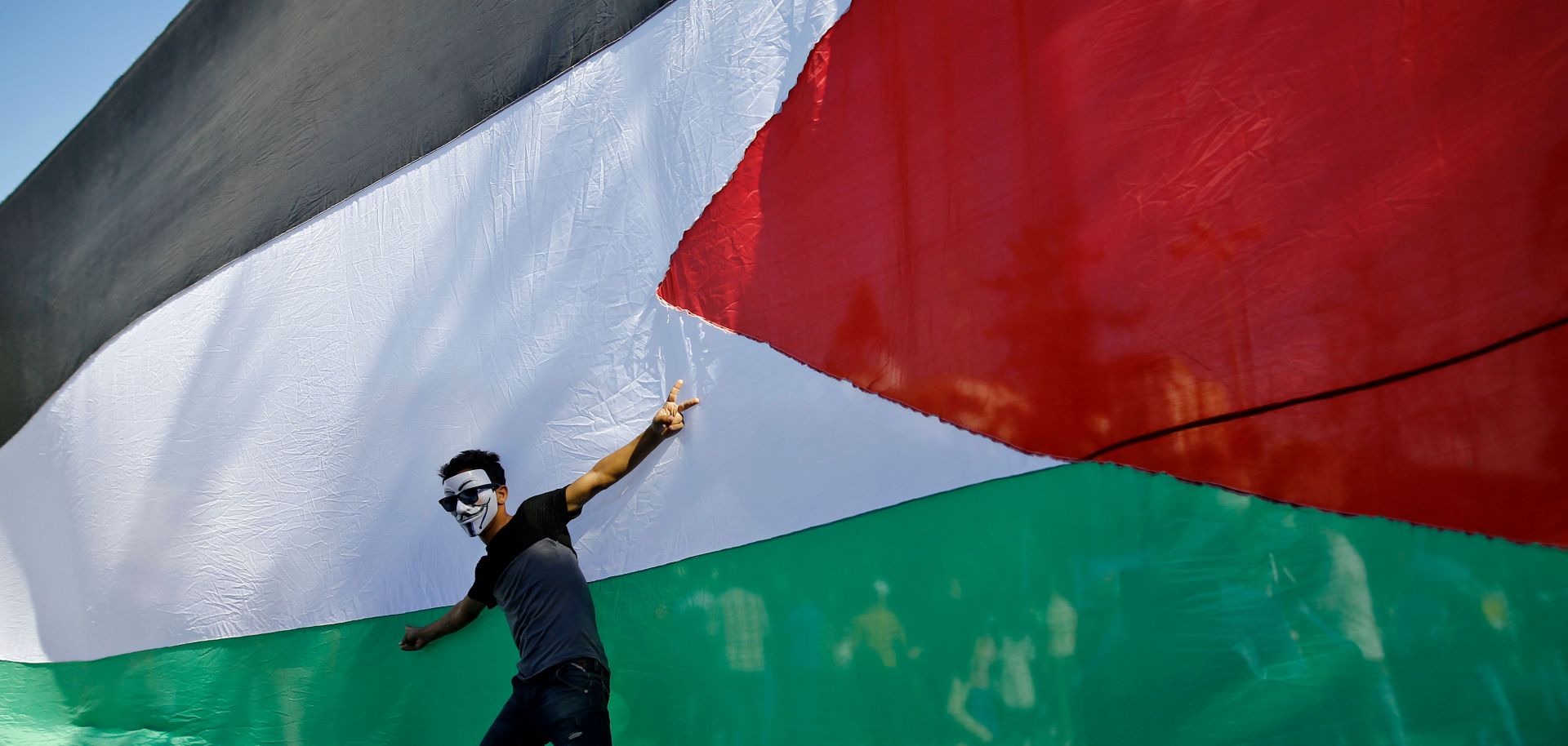A Palestinian youth poses in front of his national flag during celebrations in Gaza City after rival Palestinian factions Hamas and Fatah reached an agreement ending their decadelong split on Oct. 12.