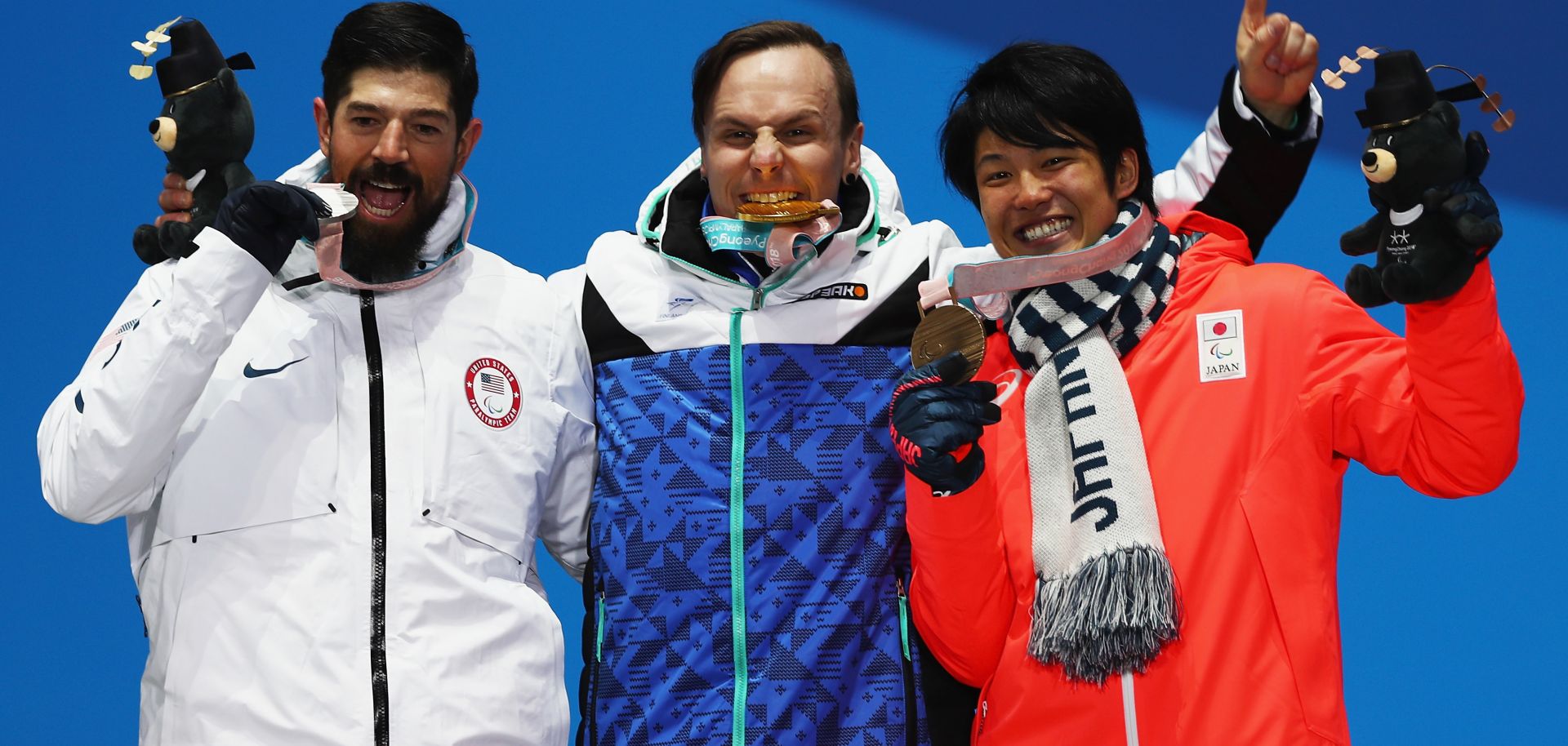 Finnish snowboarder Matti Suur-Hamari, center, celebrates his gold medal win with silver medalist Keith Gabel of the United States, left, and Gurimu Narita of Japan.