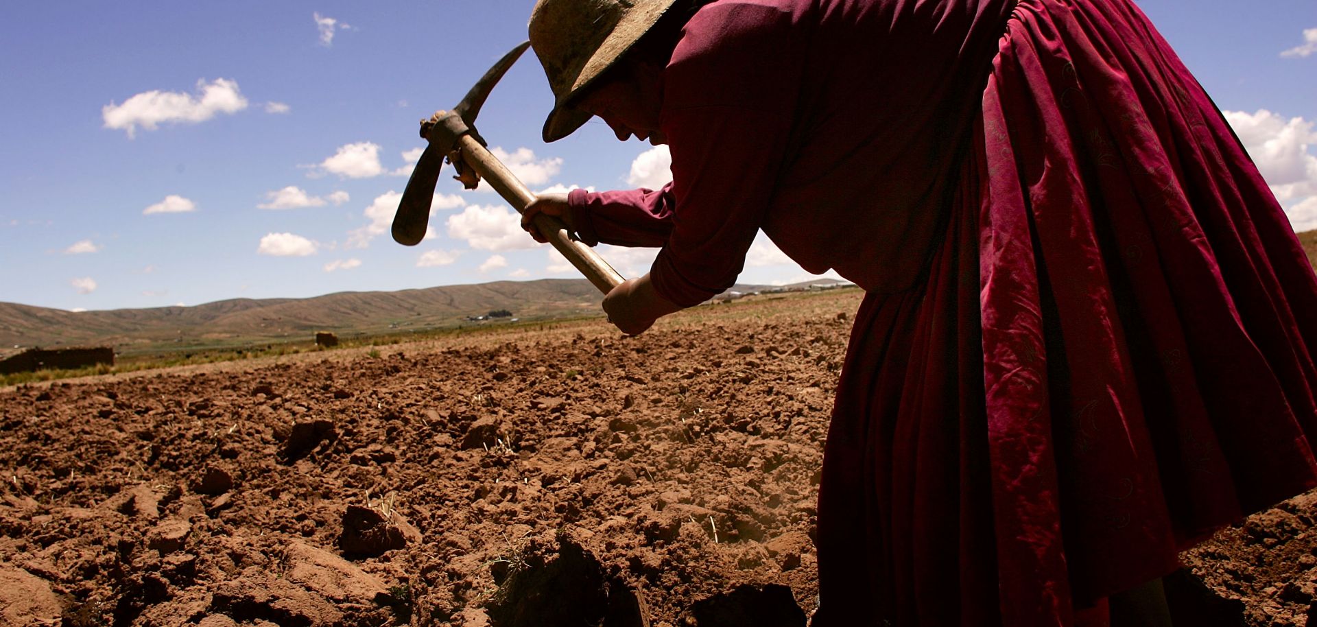 A woman tills a field in Bolivia.