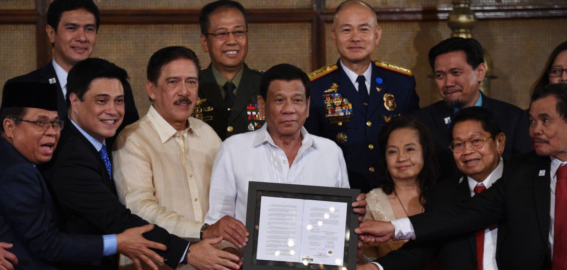 Philippine President Rodrigo Duterte, center, poses with lawmakers, leaders of the Moro Islamic Liberation Front and military and police officials during a presentation ceremony for the new Bangsamoro law in Manila on Aug. 6, 2018.