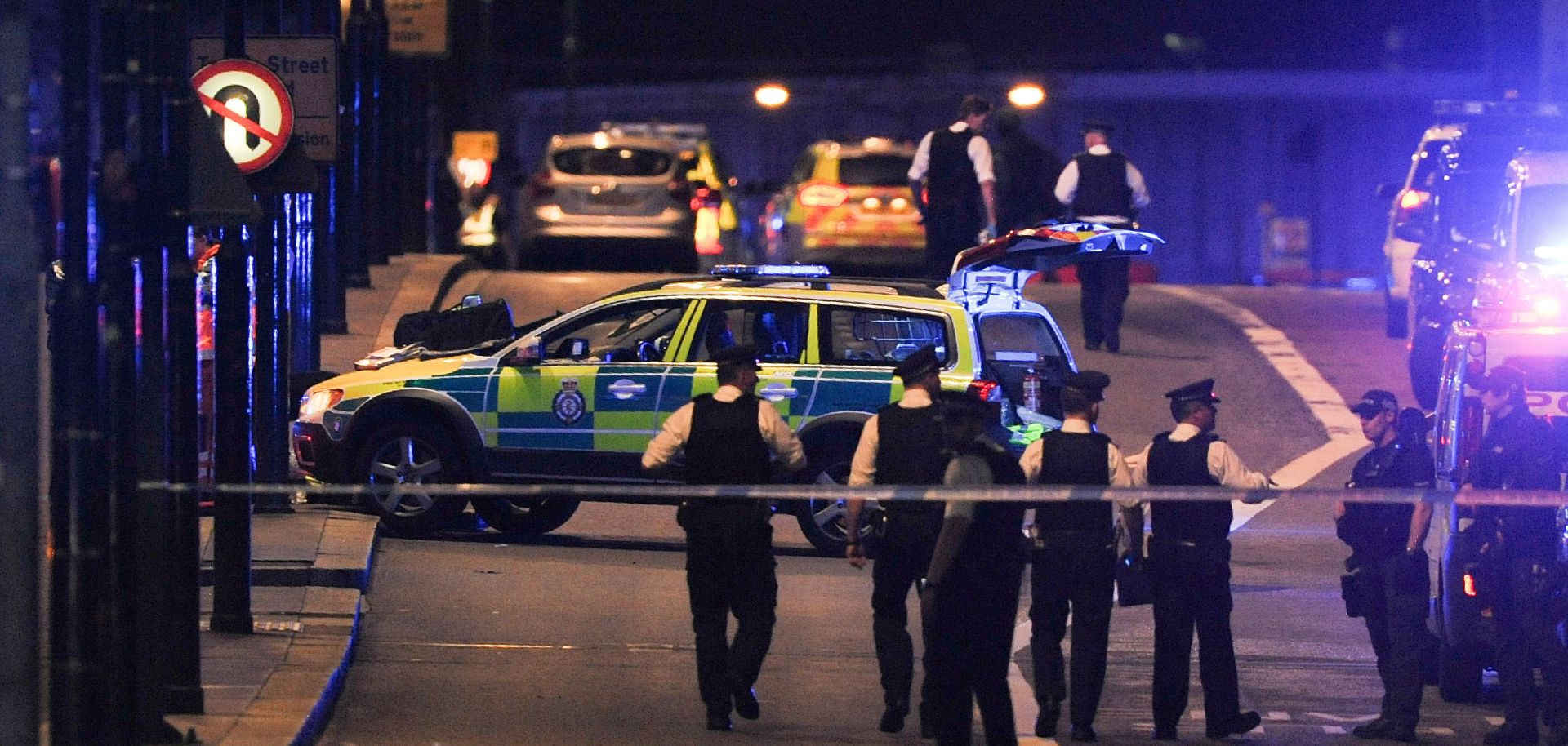 Police officers walk at night along the London Bridge after a terrorist attack.