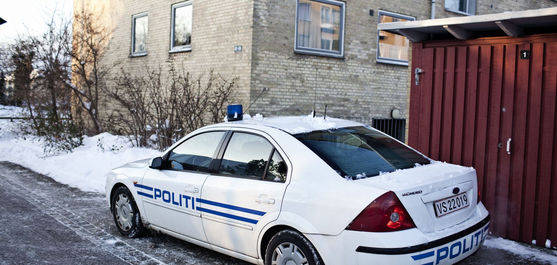 A police car is parked outside of the place where Islamist militants were arrested, suspected of a plot to massacre staff at a Danish newspaper.