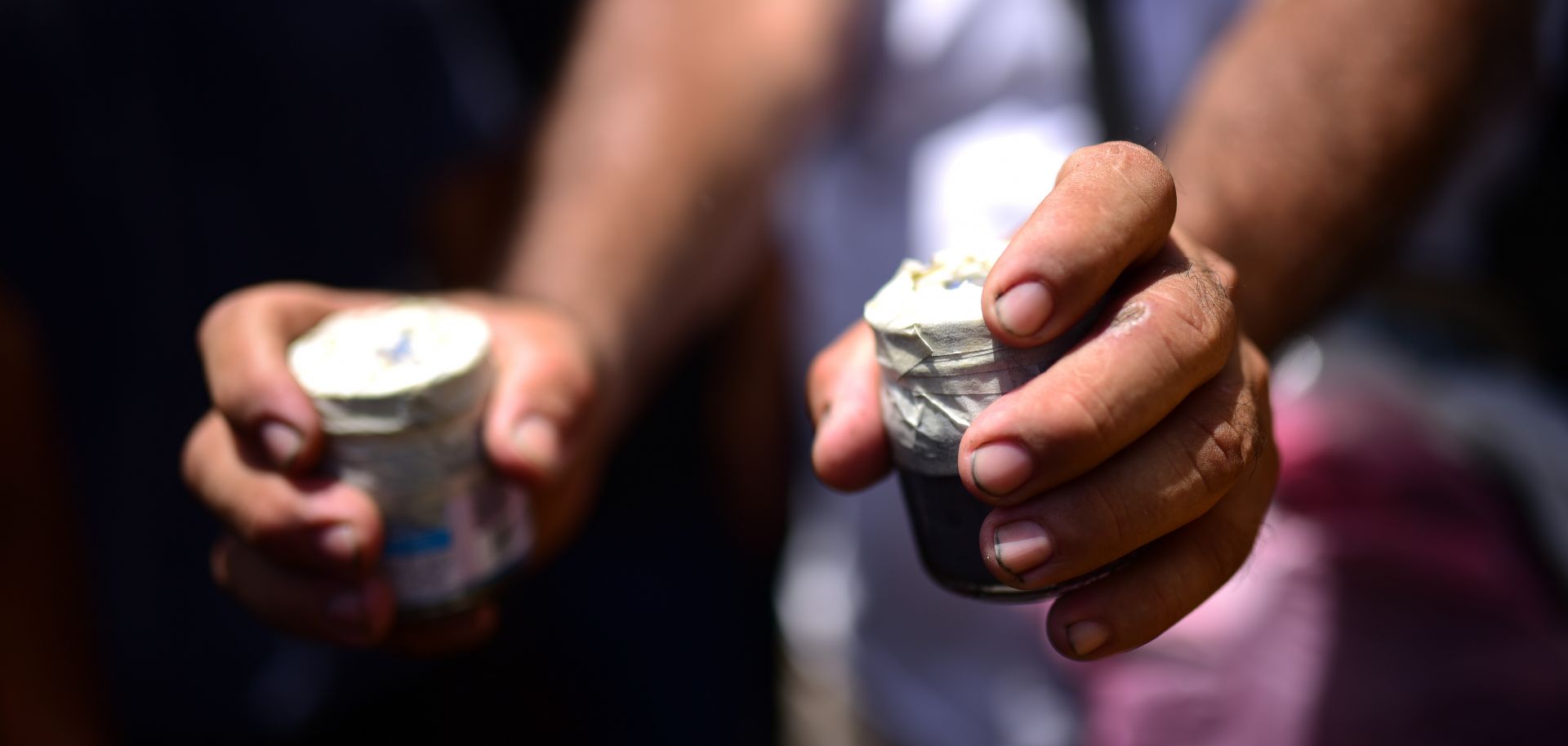 A protestor in Nicaragua shows off two homemade bombs.