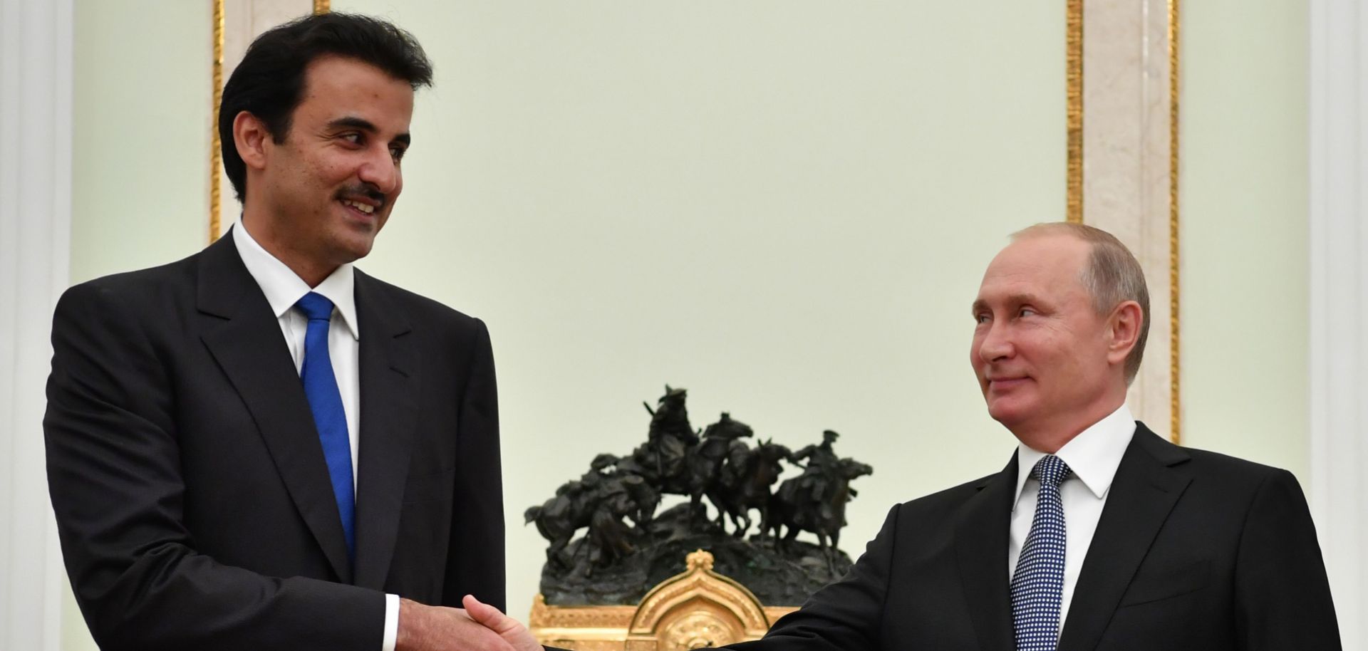 Emir of Qatar Sheikh Tamim bin Hamad Al-Thani (L) shakes hands with Russian President Vladimir Putin during their meeting at the Kremlin in Moscow on July 15.