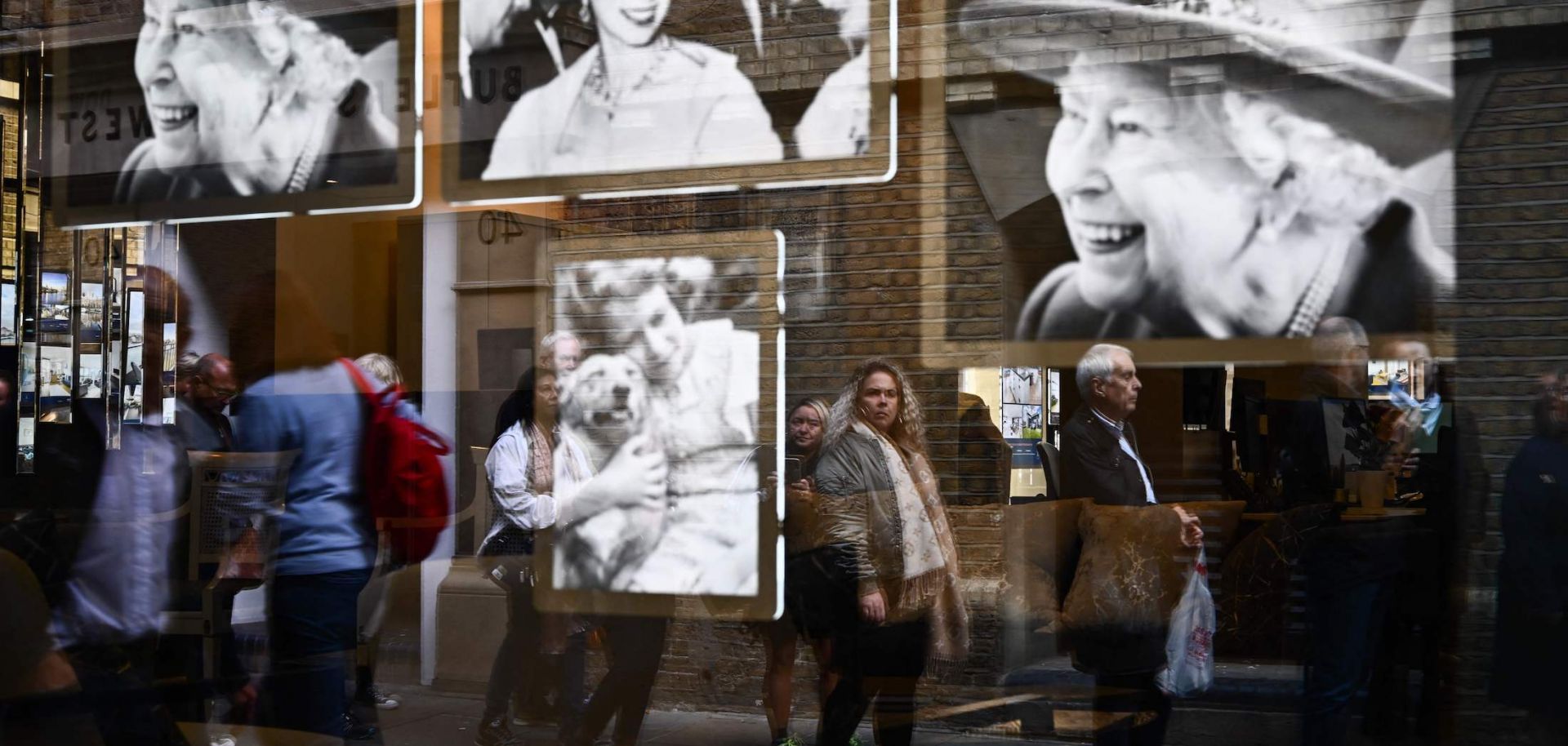 Pictures of Britain's Queen Elizabeth II in a window as members of the public wait in line to pay their respects to the late monarch Sept. 16, 2022, in London.