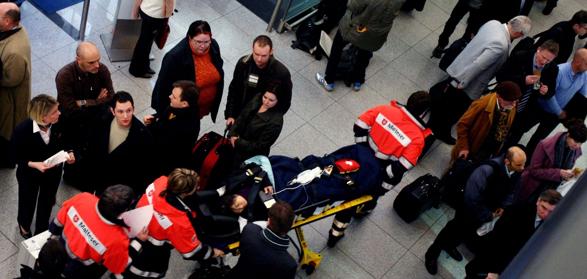 Rescue helper carries out a woman on a stretcher after a bomb alter at terminal 2 on the Munich airport.