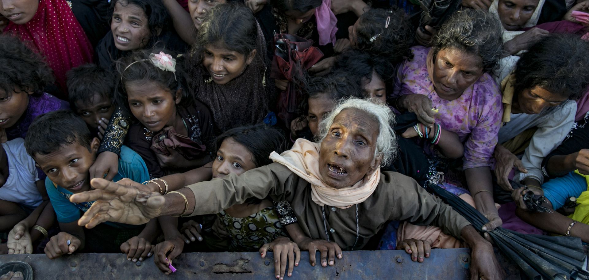 A throng of Rohingya refugees recently arrived in Bangladesh await aid donations.