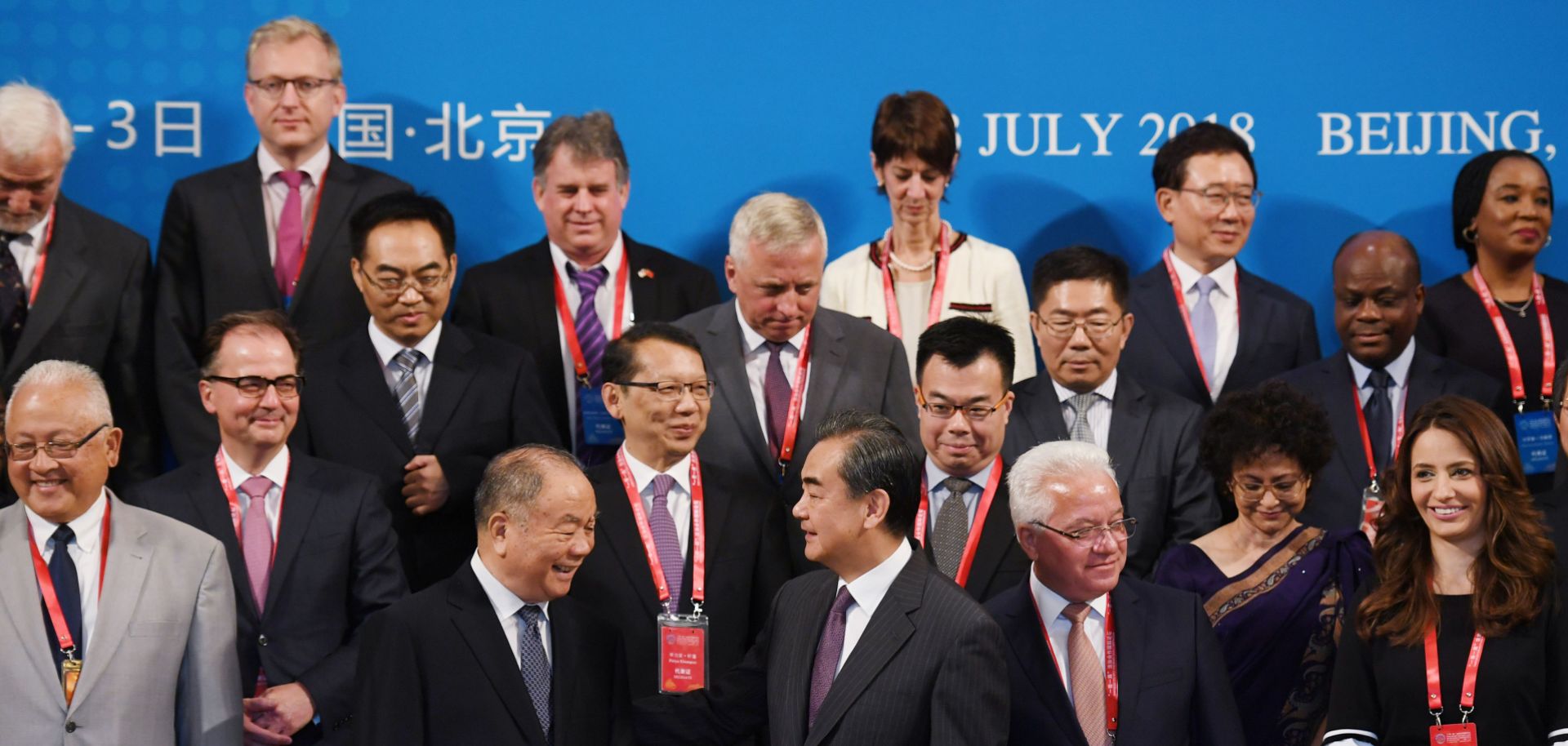 Chinese Foreign Minister Wang Yi, front center, stands with other delegates for a group photo before the Belt and Road Forum on Legal Cooperation began in Beijing on July 2, 2018.