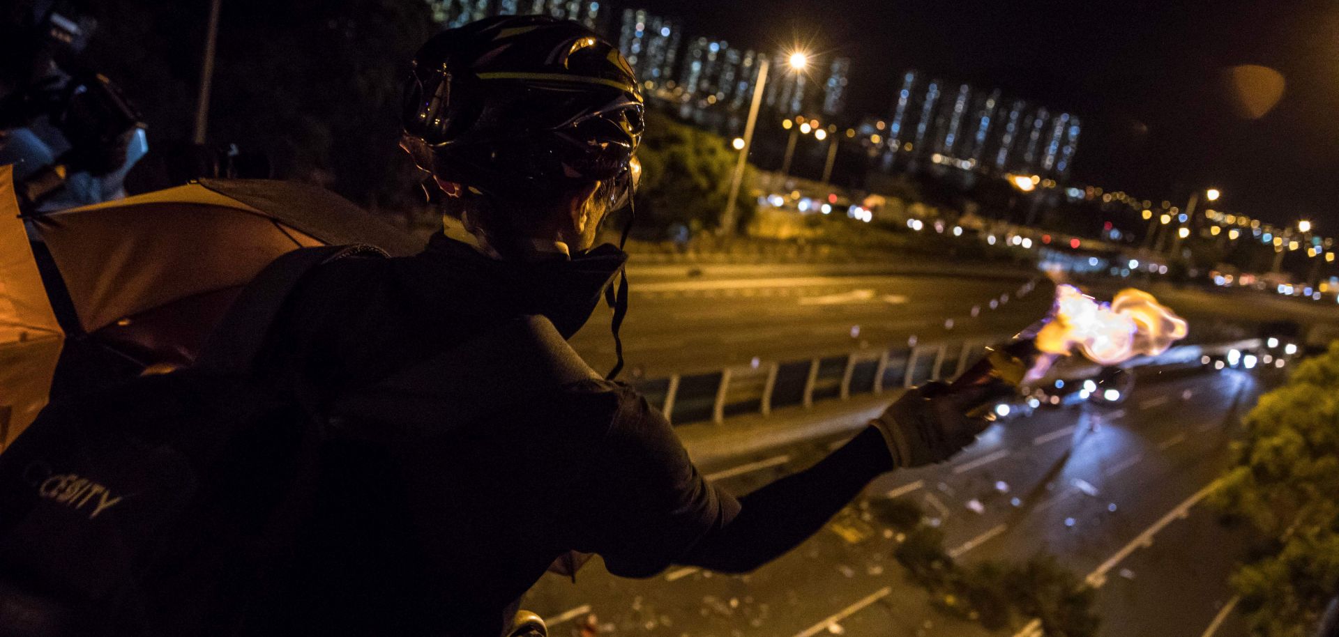 This photo shows a protester in Hong Kong throwing a Molotov cocktail to stop vehicles from passing through a barricade beneath a bridge at the Chinese University of Hong Kong on Nov. 15, 2019.