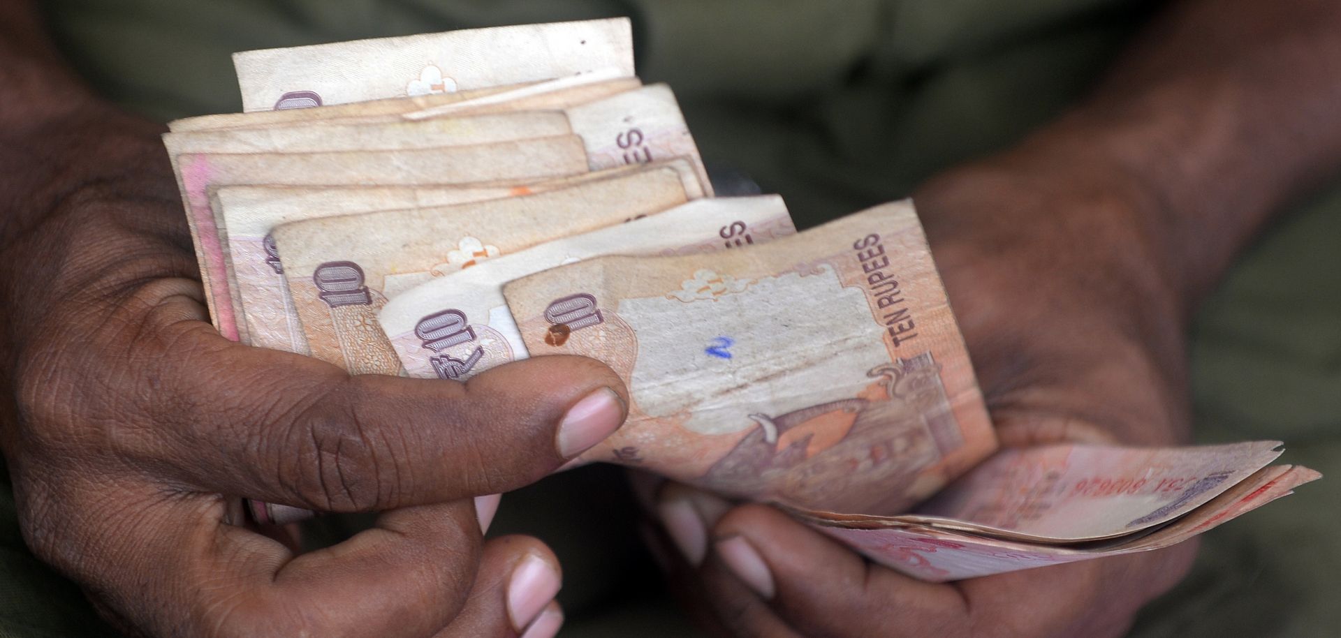 A bus conductor counts currency notes at the end of a trip in Mumbai.