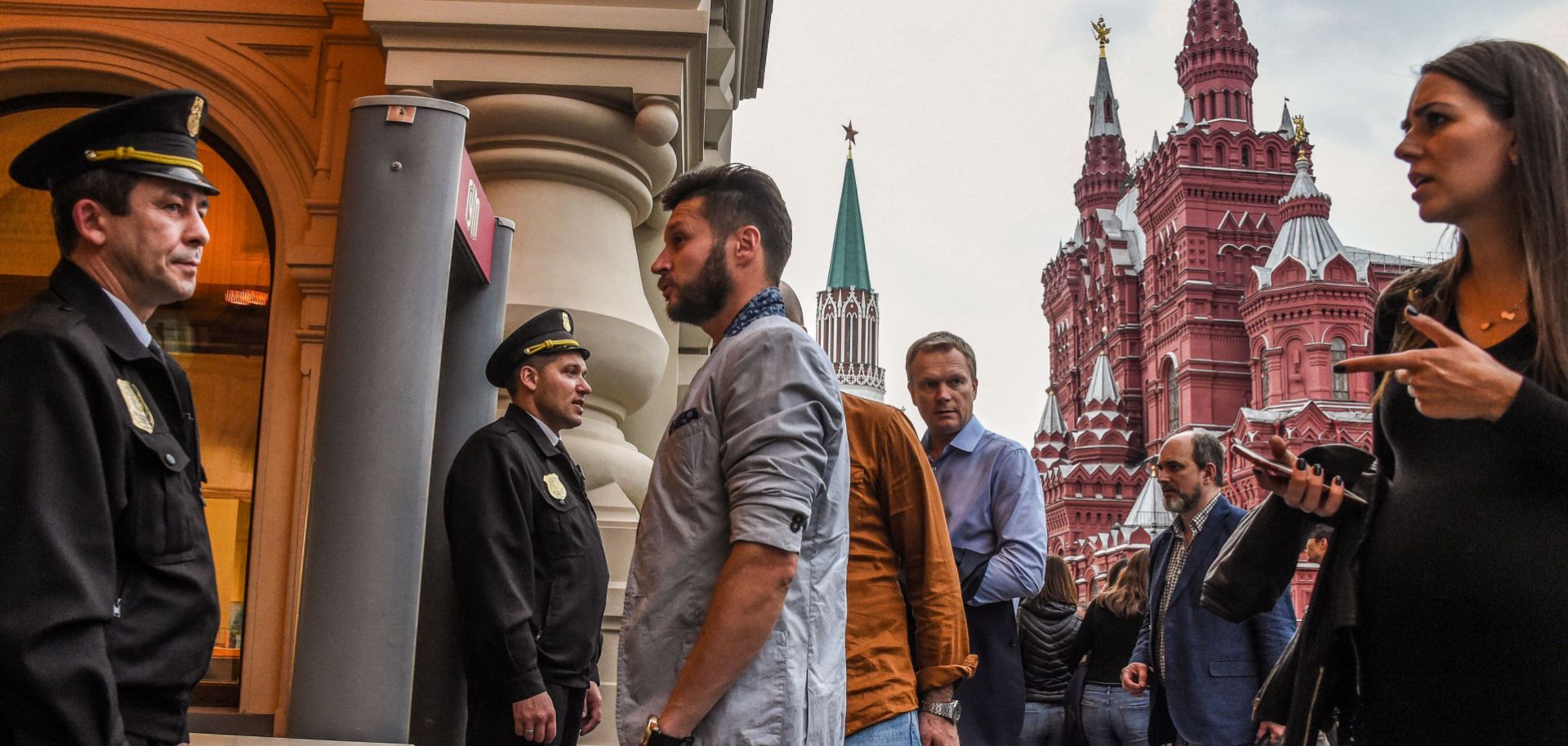 Visitors wait by security personnel in front of the entrance of a department store near Red Square in Moscow on Sept. 13. 